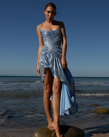 Vestido largo irregular sin mangas de color sólido junto al mar